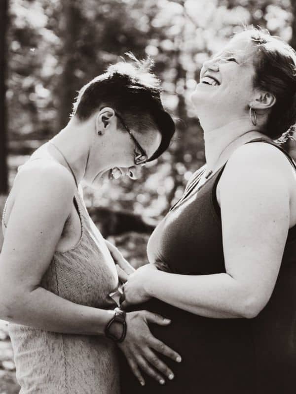 Happy Pregnant Lesbian Couple holding pregnant belly
